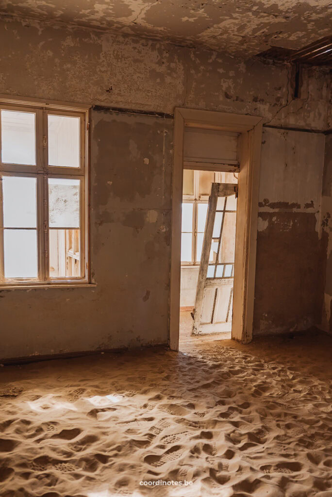 Inside a house, everything covered in sand